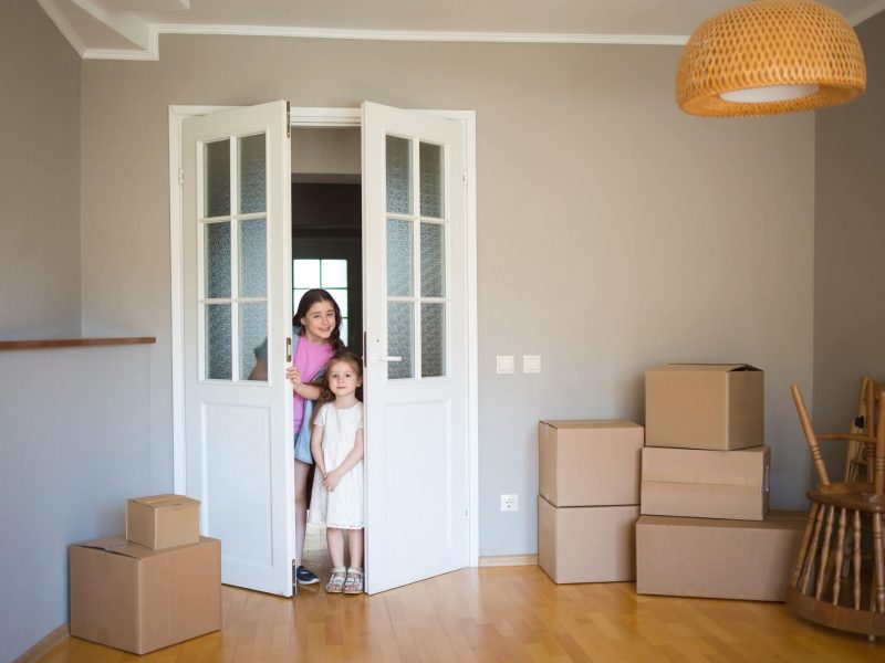 children-look-into-its-new-home-moving-to-apartment-boxes-in-house-1-1.jpg